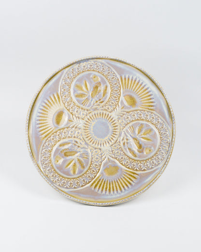 Top view of a decorative cake stand with gold and white patterns on a white background