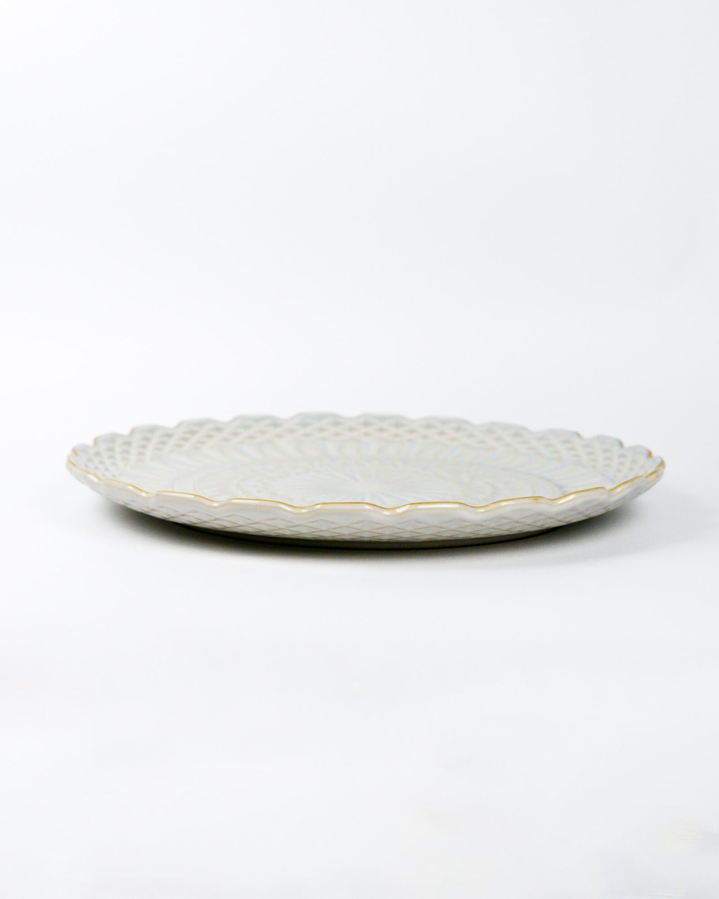 Decorative ceramic plate with textured design on a white background