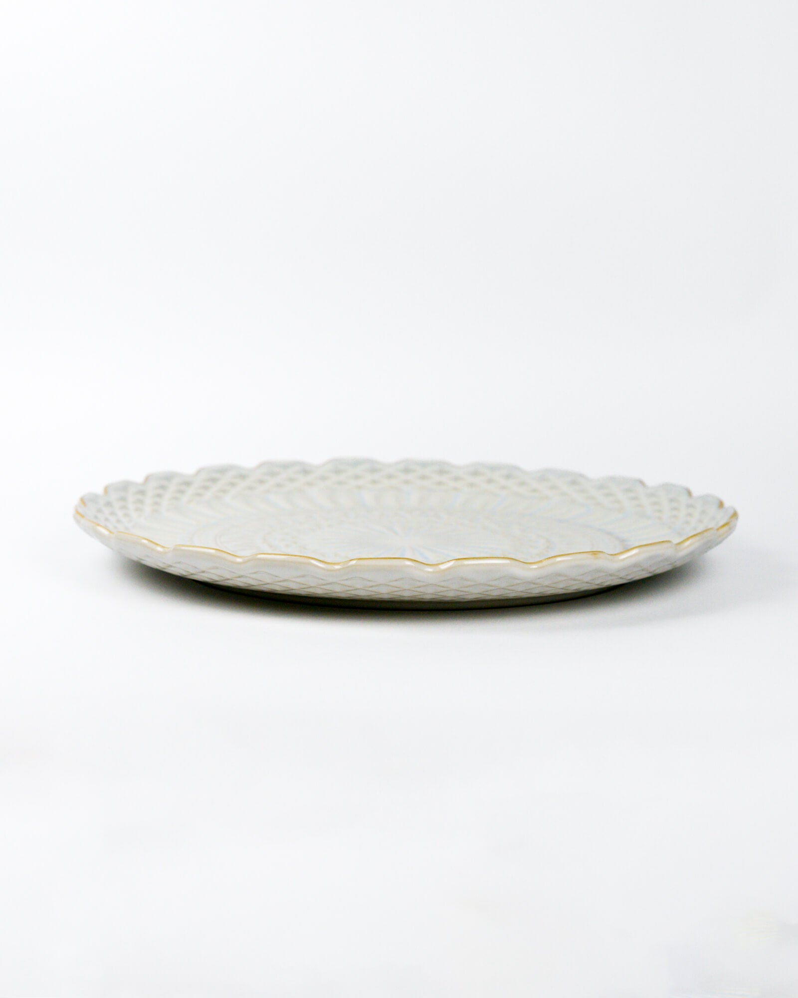 Decorative ceramic plate with textured design on a white background