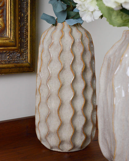 Decorative ceramic vase with wavy pattern on a wooden surface