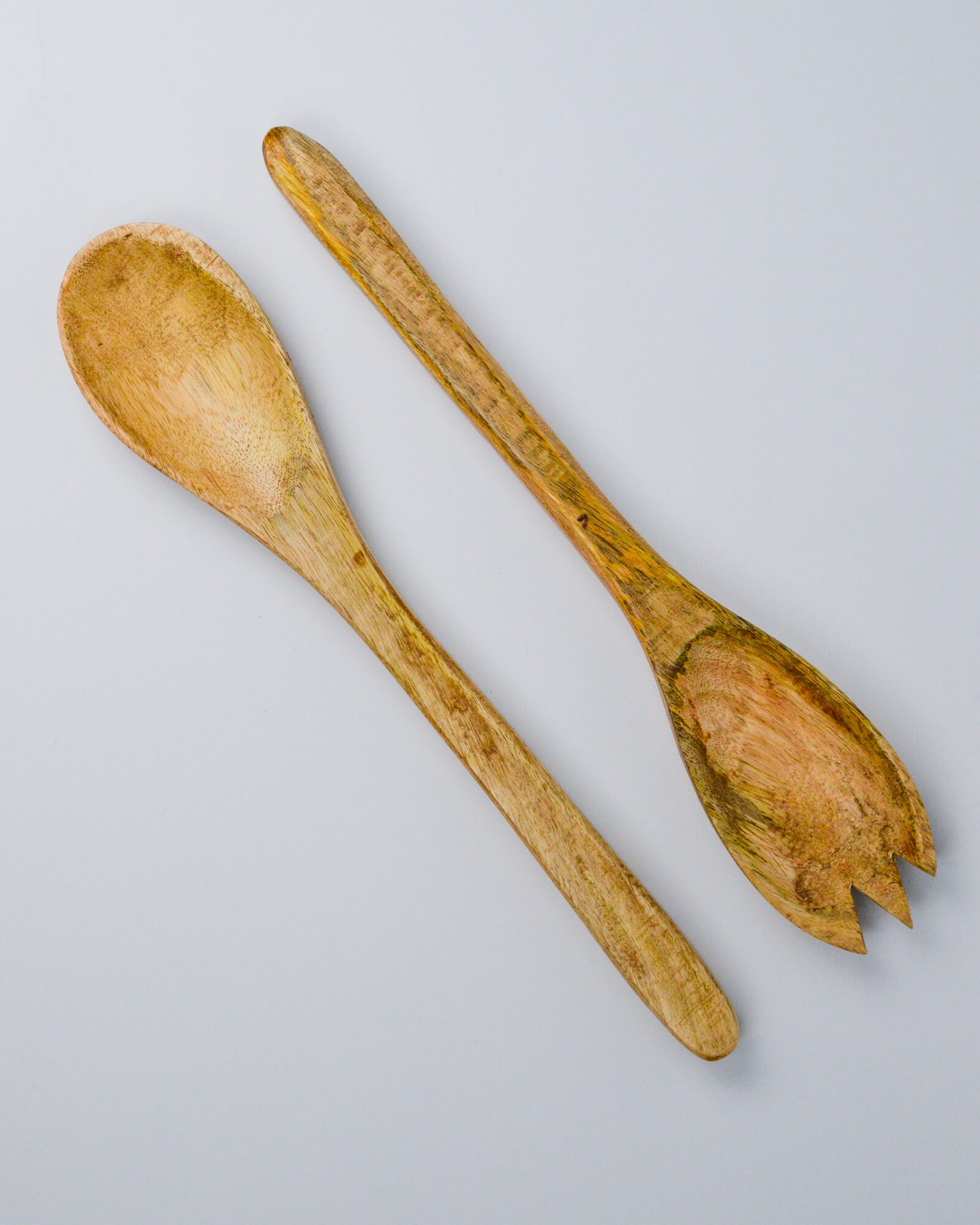 Wooden spoon and fork salad server set on a white background