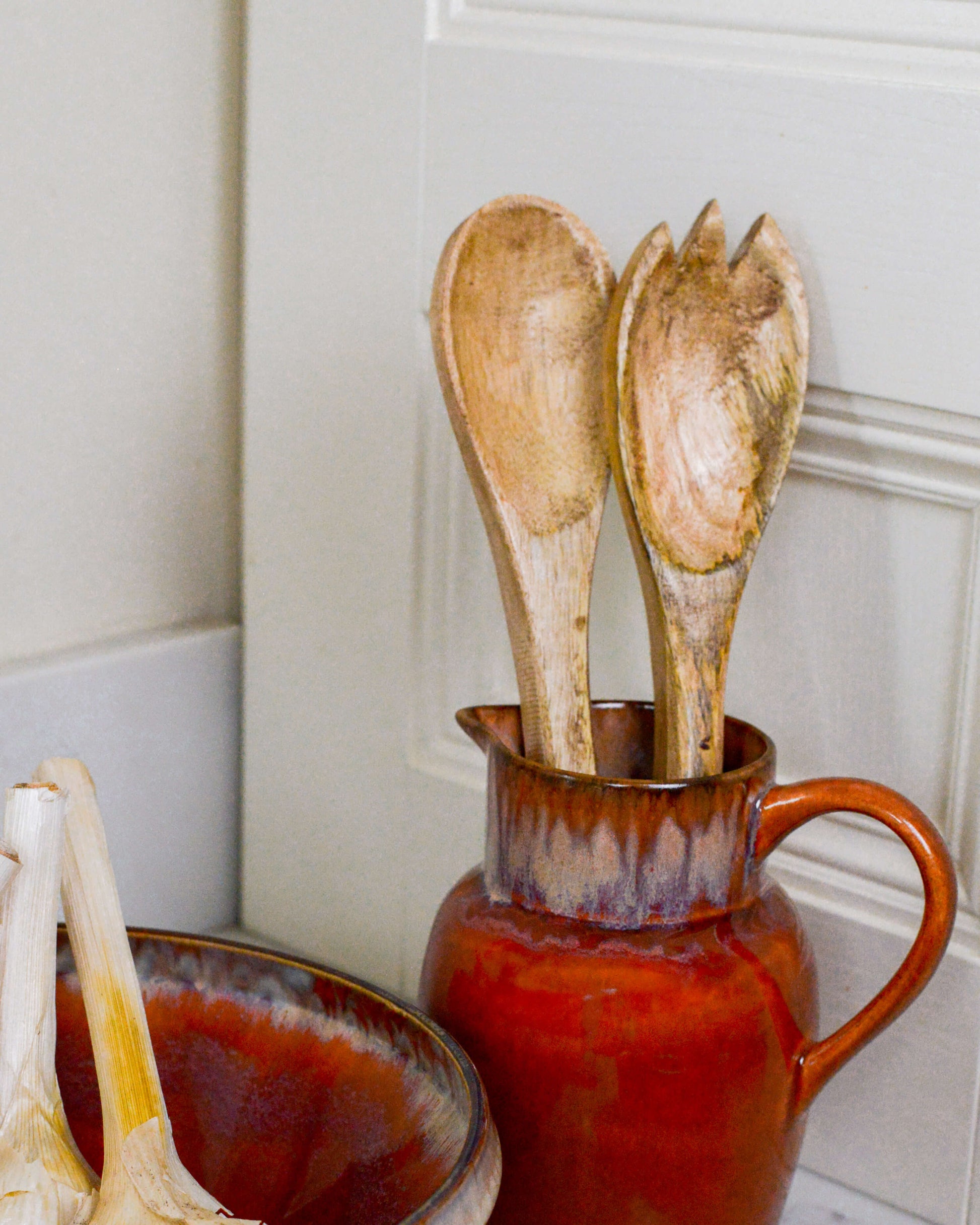 Salad servers on display in a ceramic pitcher 