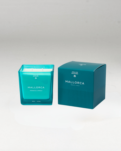A teal glass jar candle next to its matching teal packaging box, both featuring the name 'MALLORCA'