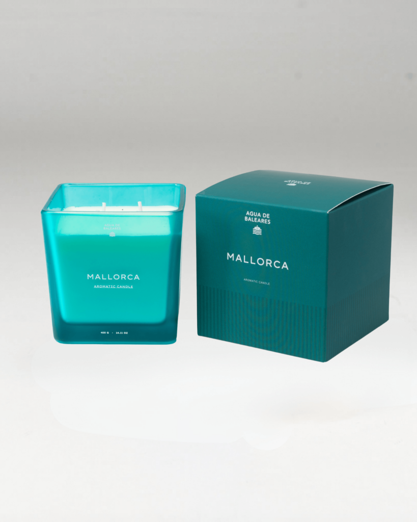 A teal glass jar candle labeled MALLORCA next to its matching teal box packaging, set against a neutral light gray background.