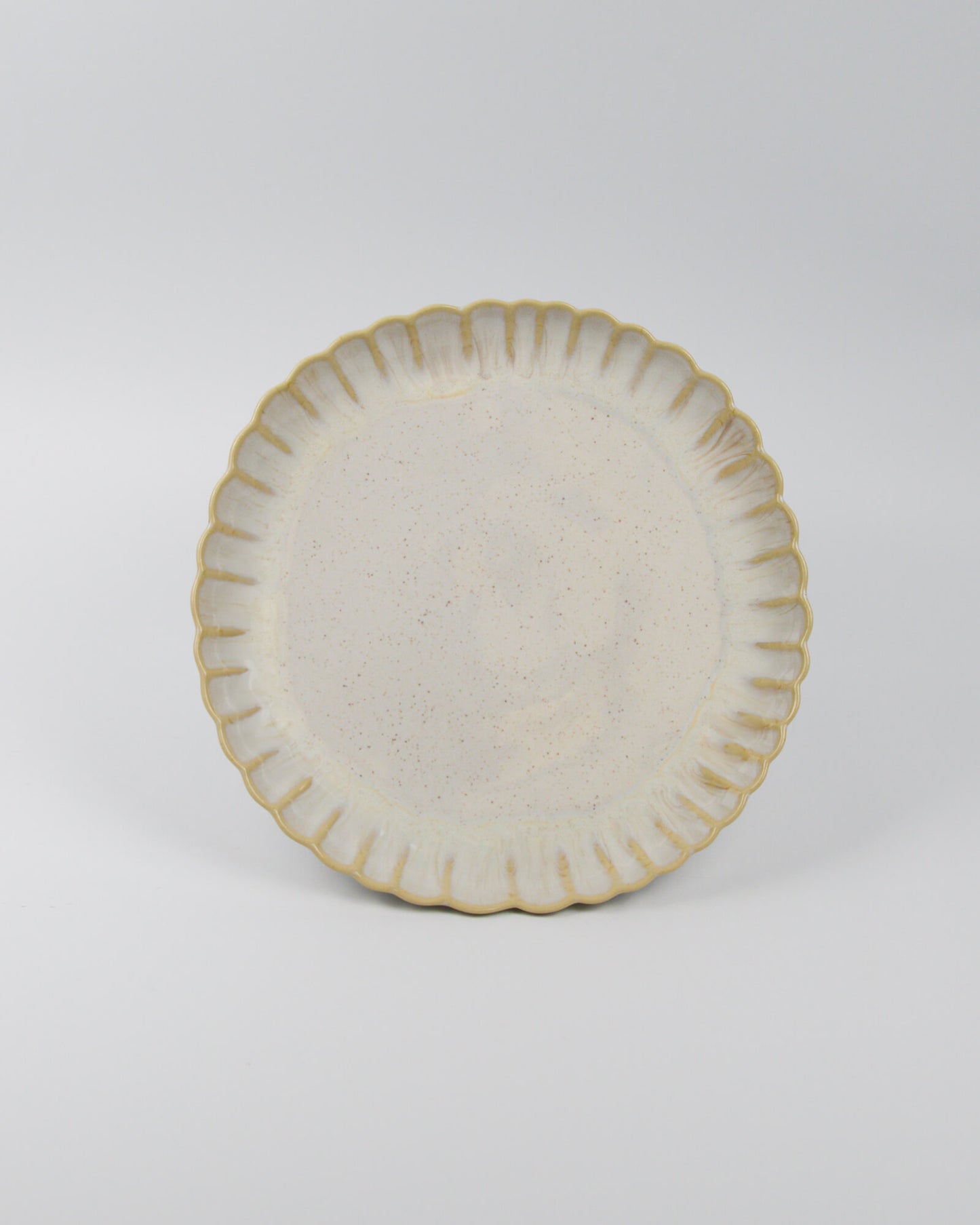 Ceramic stoneware plate with decorative edge on a white background