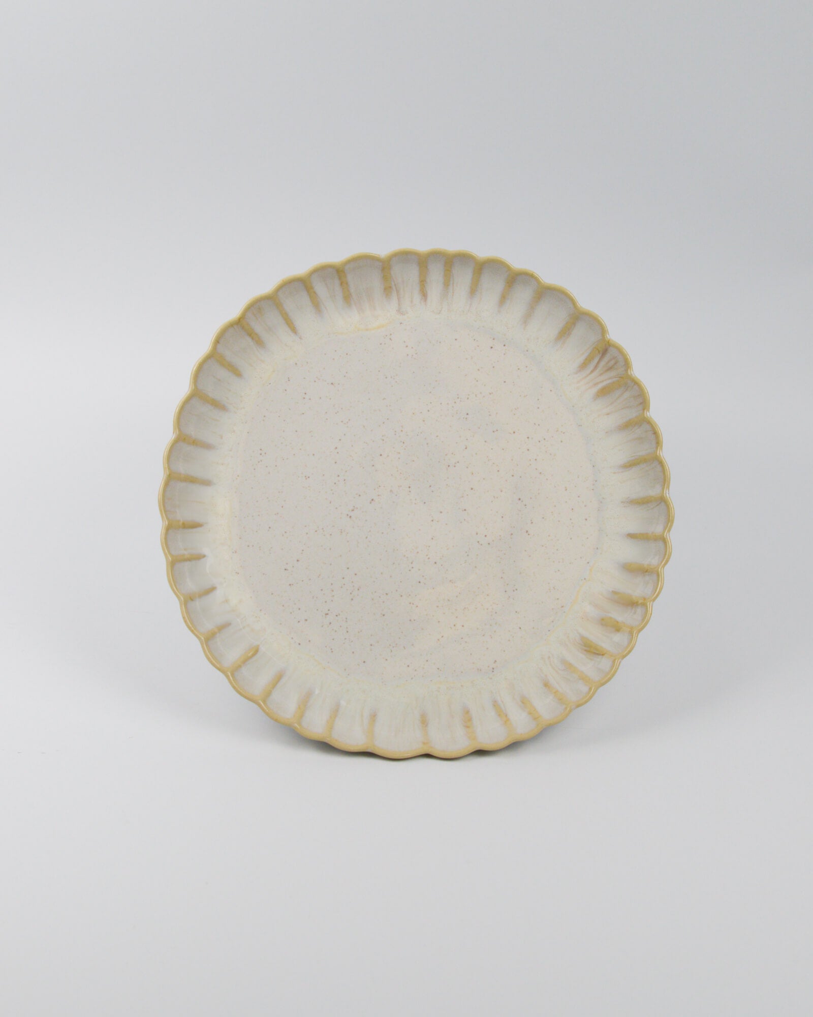 Ceramic stoneware plate with decorative edge on a white background
