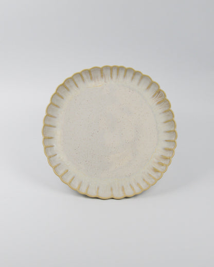 Ceramic stoneware plate with decorative edge on a white background