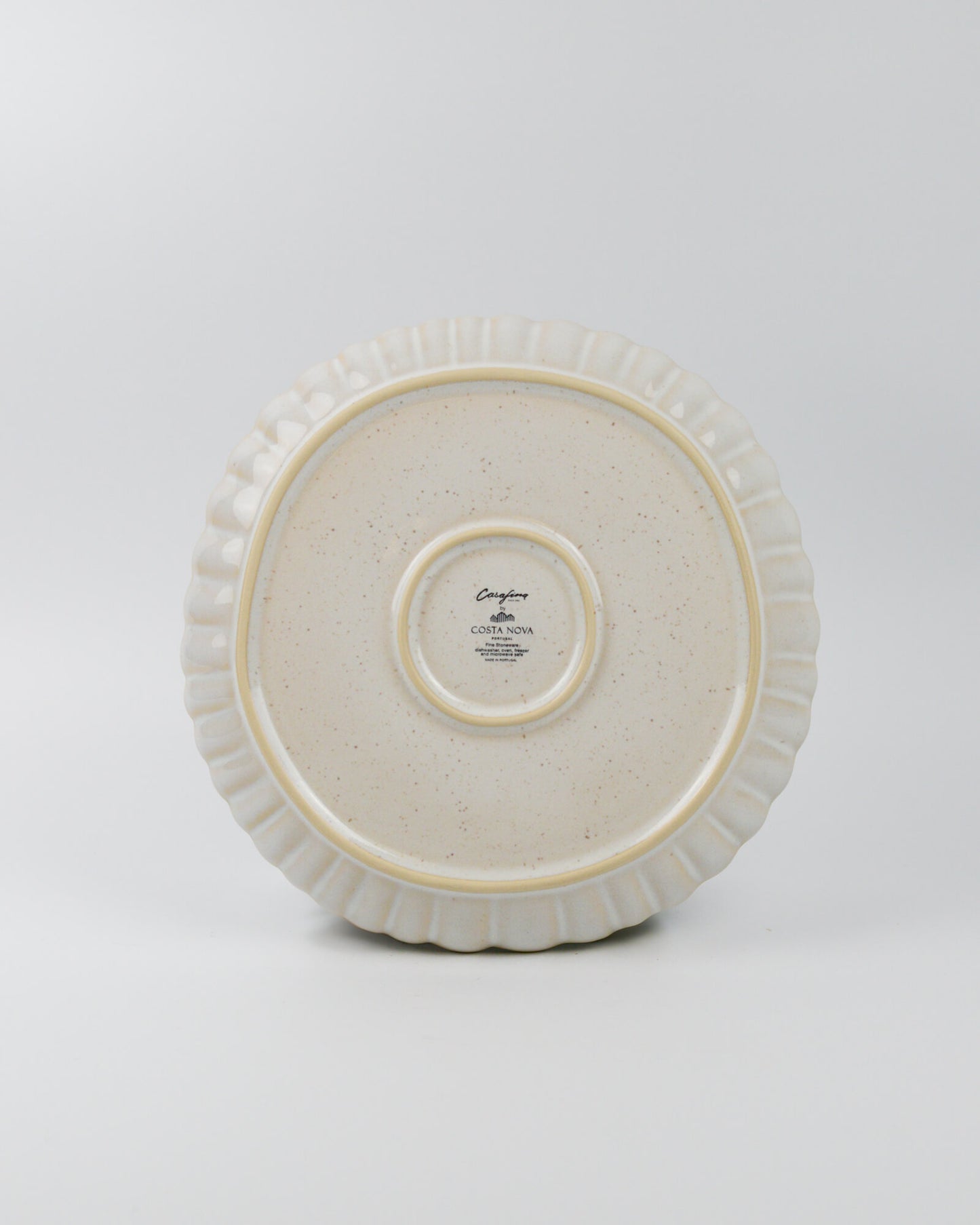 White ceramic dinner plate with decorative rim on a white background