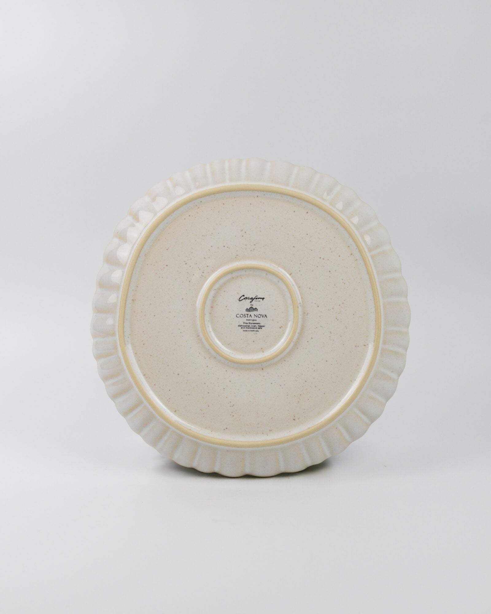 White ceramic dinner plate with decorative rim on a white background