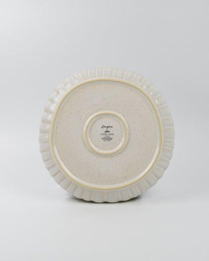 White ceramic dinner plate with decorative rim on a white background
