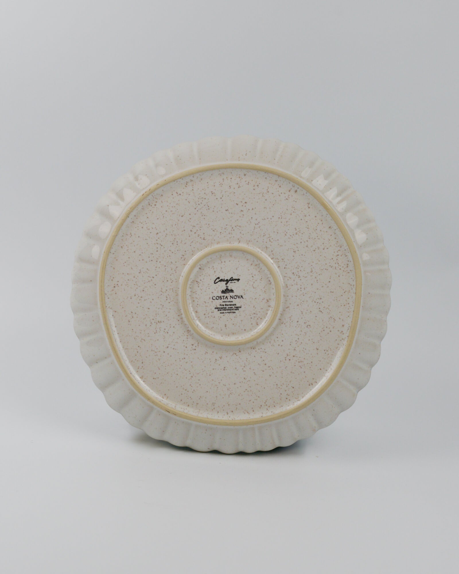 Round ceramic stonware dinner plate with textured surface on a white background