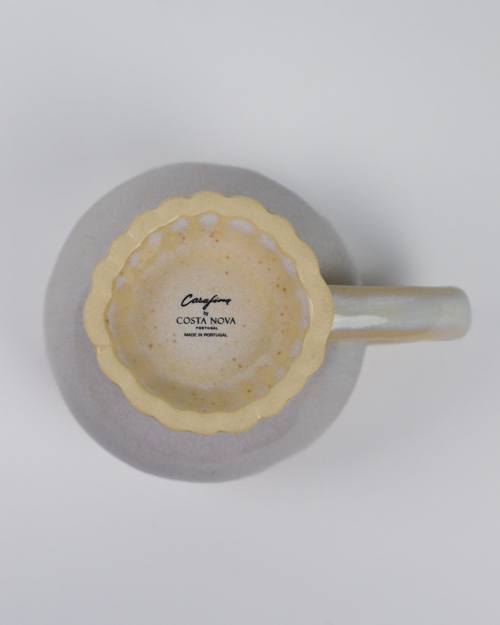 Linen coloured mug with handle and a scalloped foot