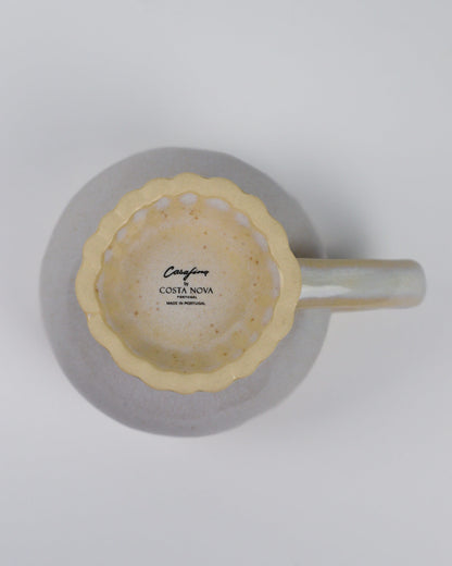 Linen coloured mug with handle and a scalloped foot