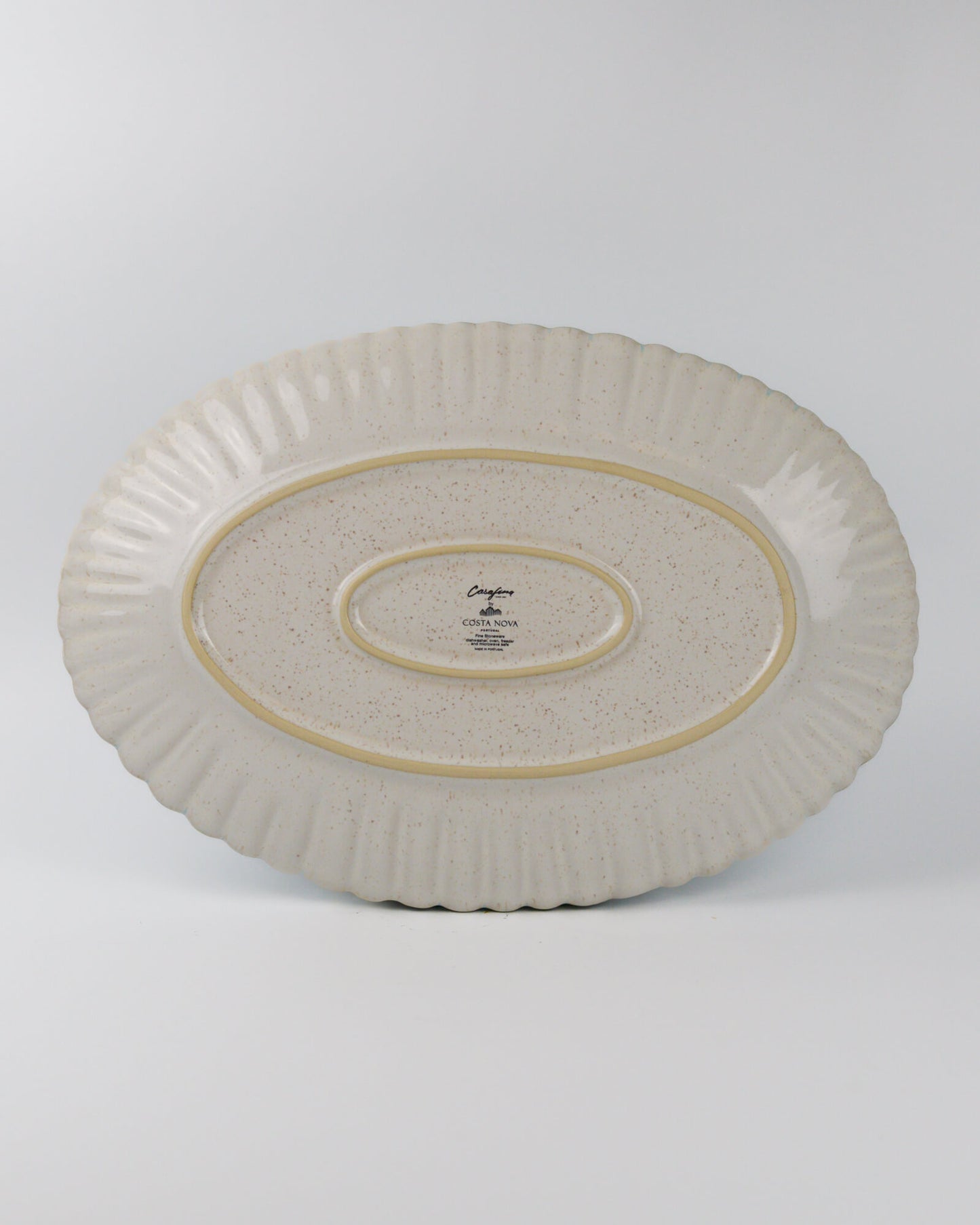 Decorative ceramic oval platter with textured design on a white background