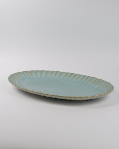 Light blue ceramic platter with textured rim on a white background