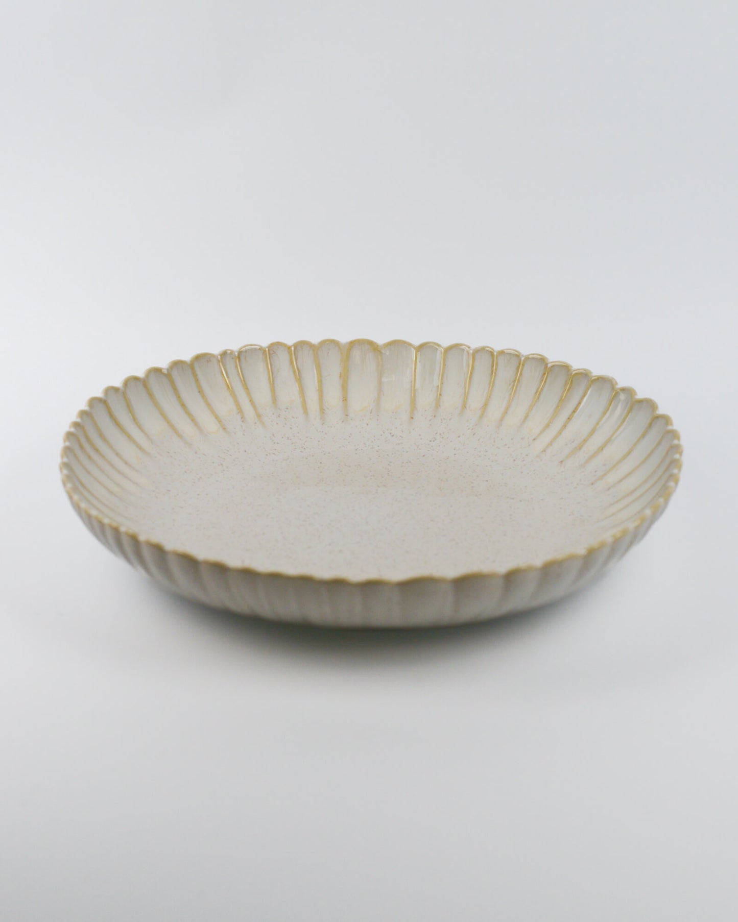 Large ceramic serving dish with decorative edge on a white background