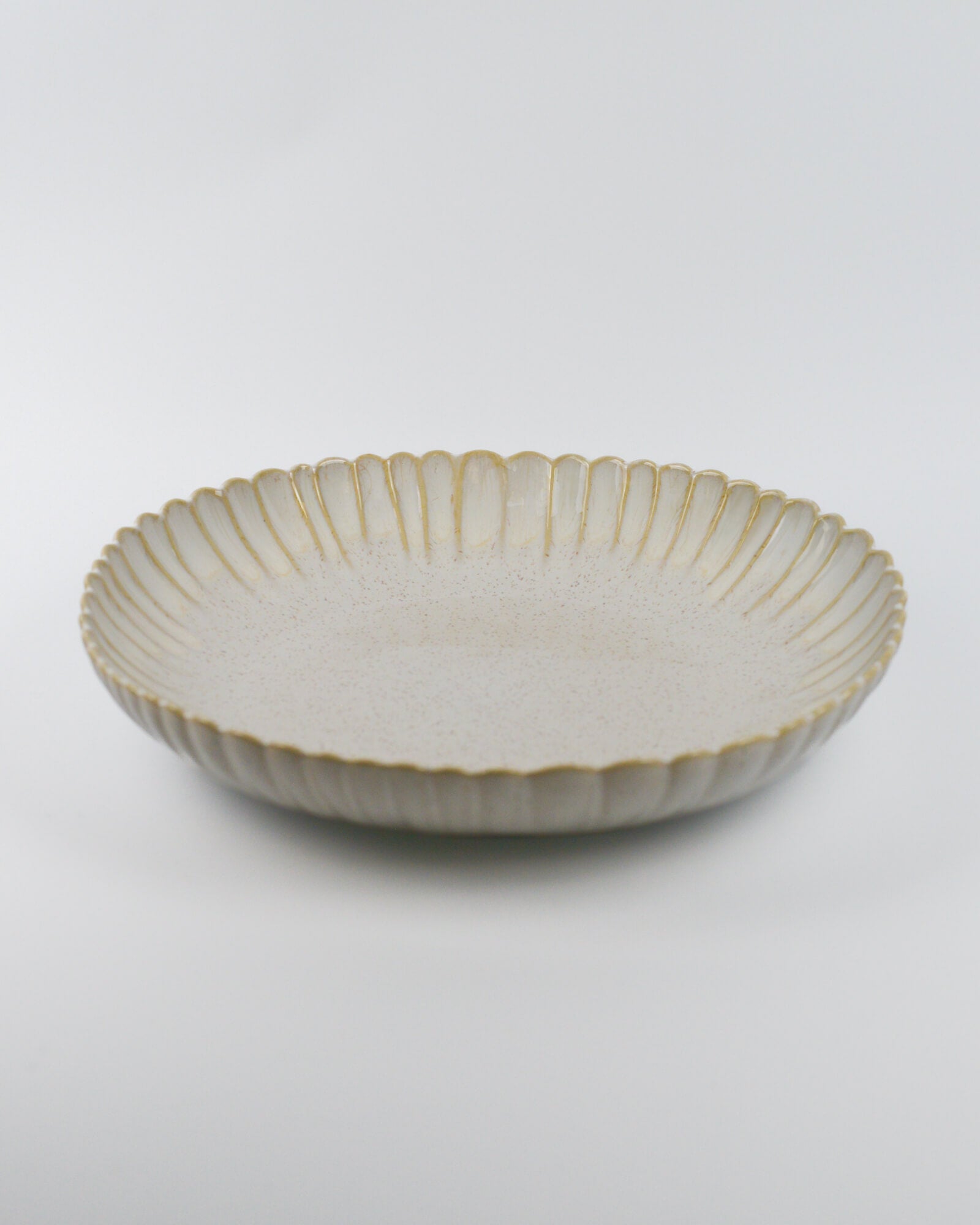 Large ceramic serving dish with decorative edge on a white background