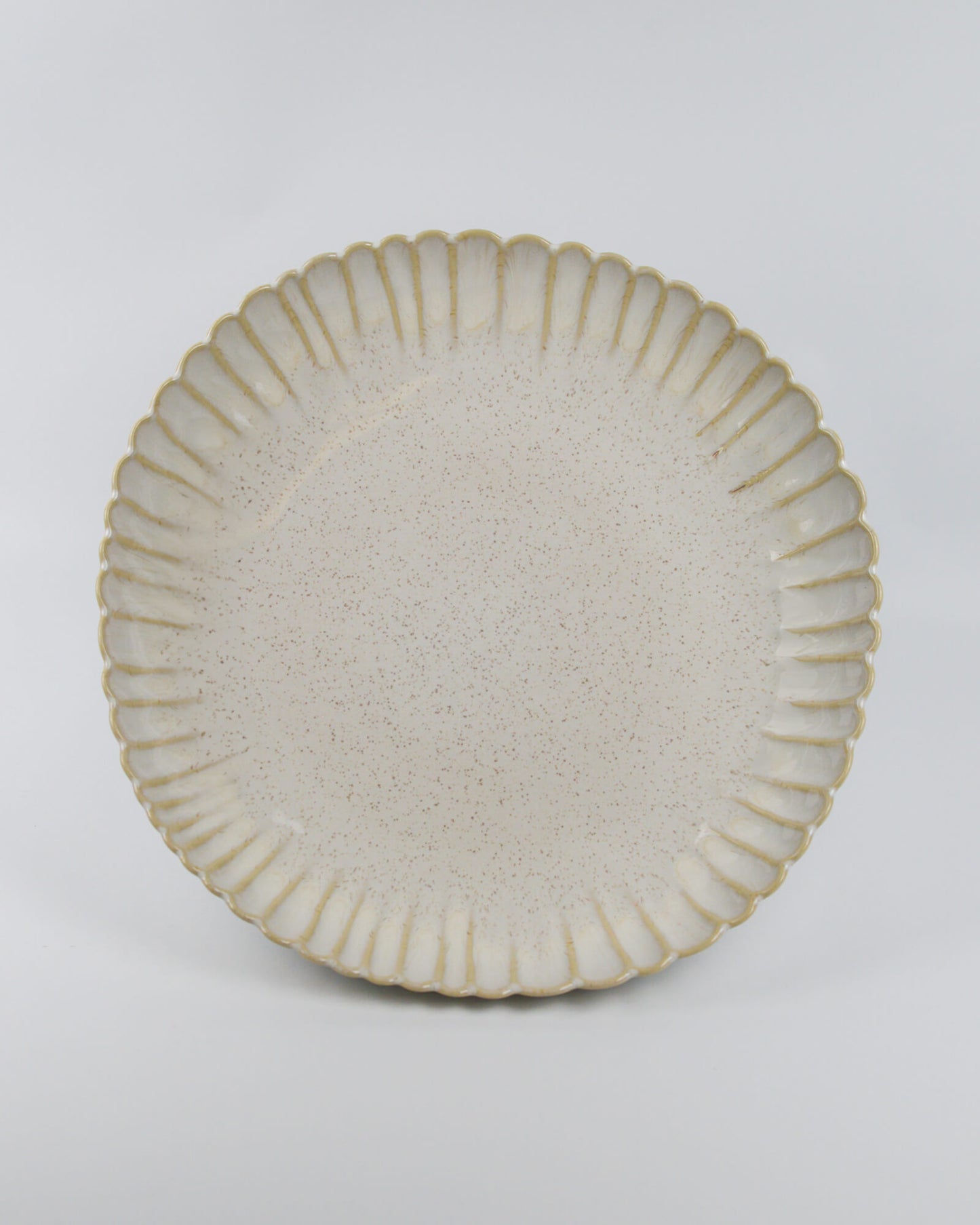 Ceramic serving dish with textured rim on a white background