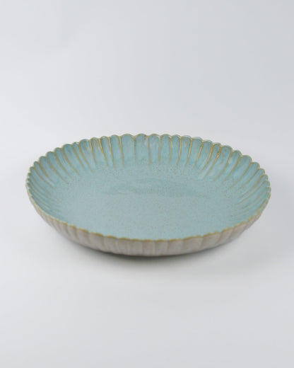 Large light blue ceramic bowl with textured rim on a white background