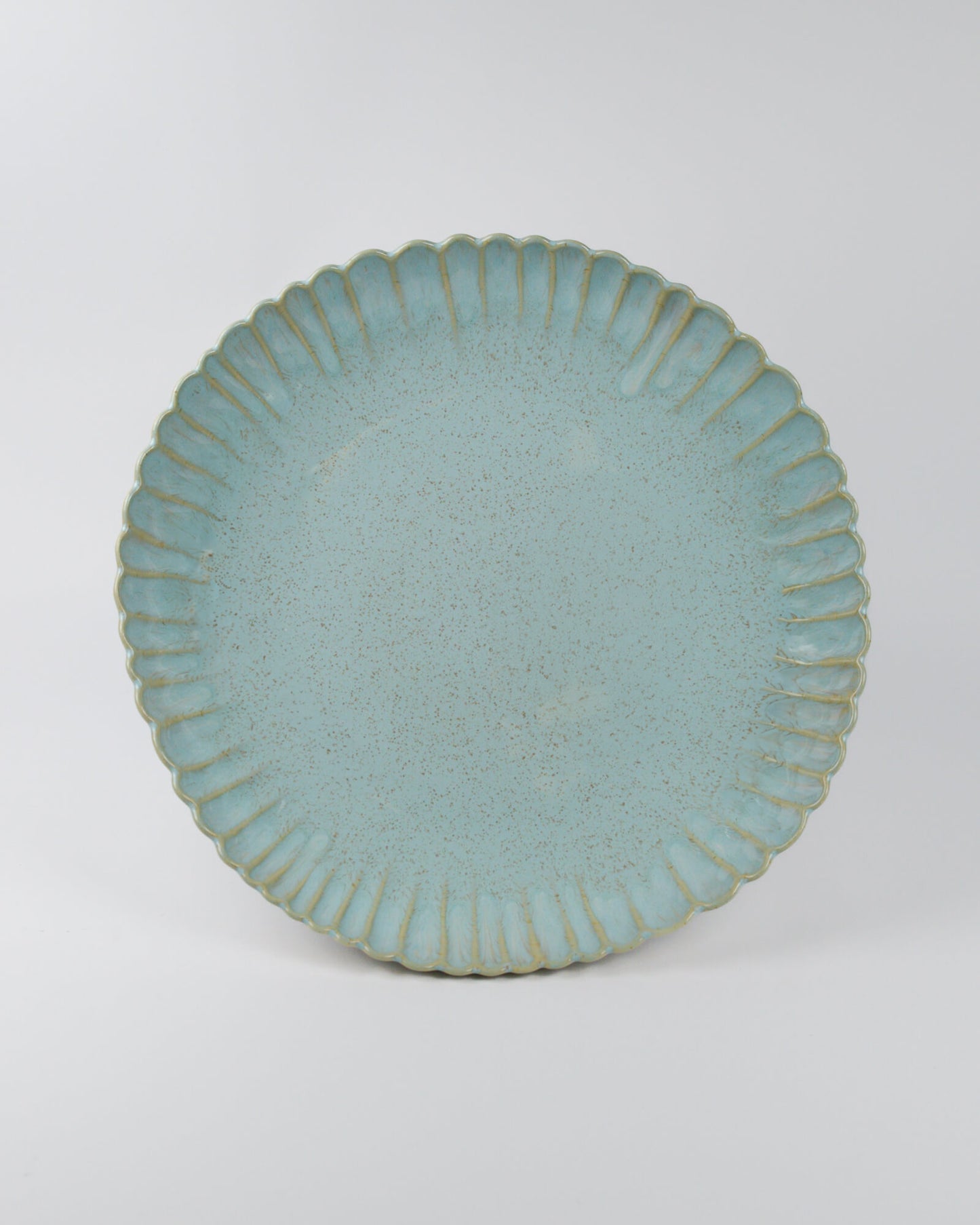 Large light blue ceramic serving dish with textured rim on a white background
