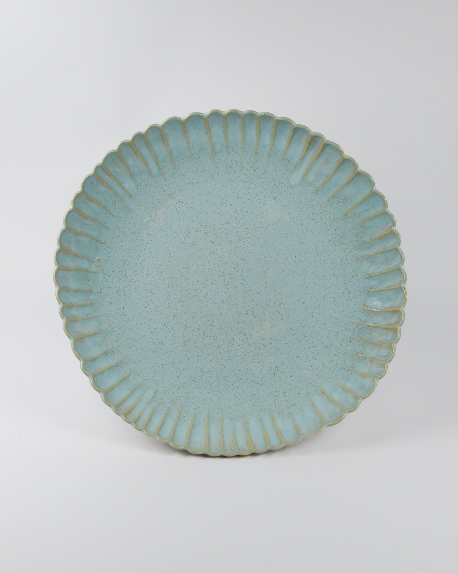 Large light blue ceramic serving dish with textured rim on a white background