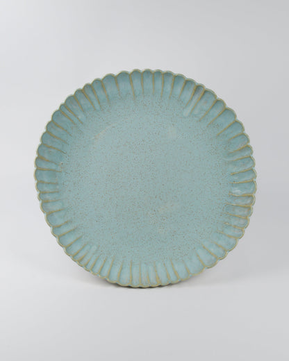 Large light blue ceramic serving dish with textured rim on a white background