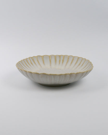 Ceramic pasta bowl with decorative edge on a white background