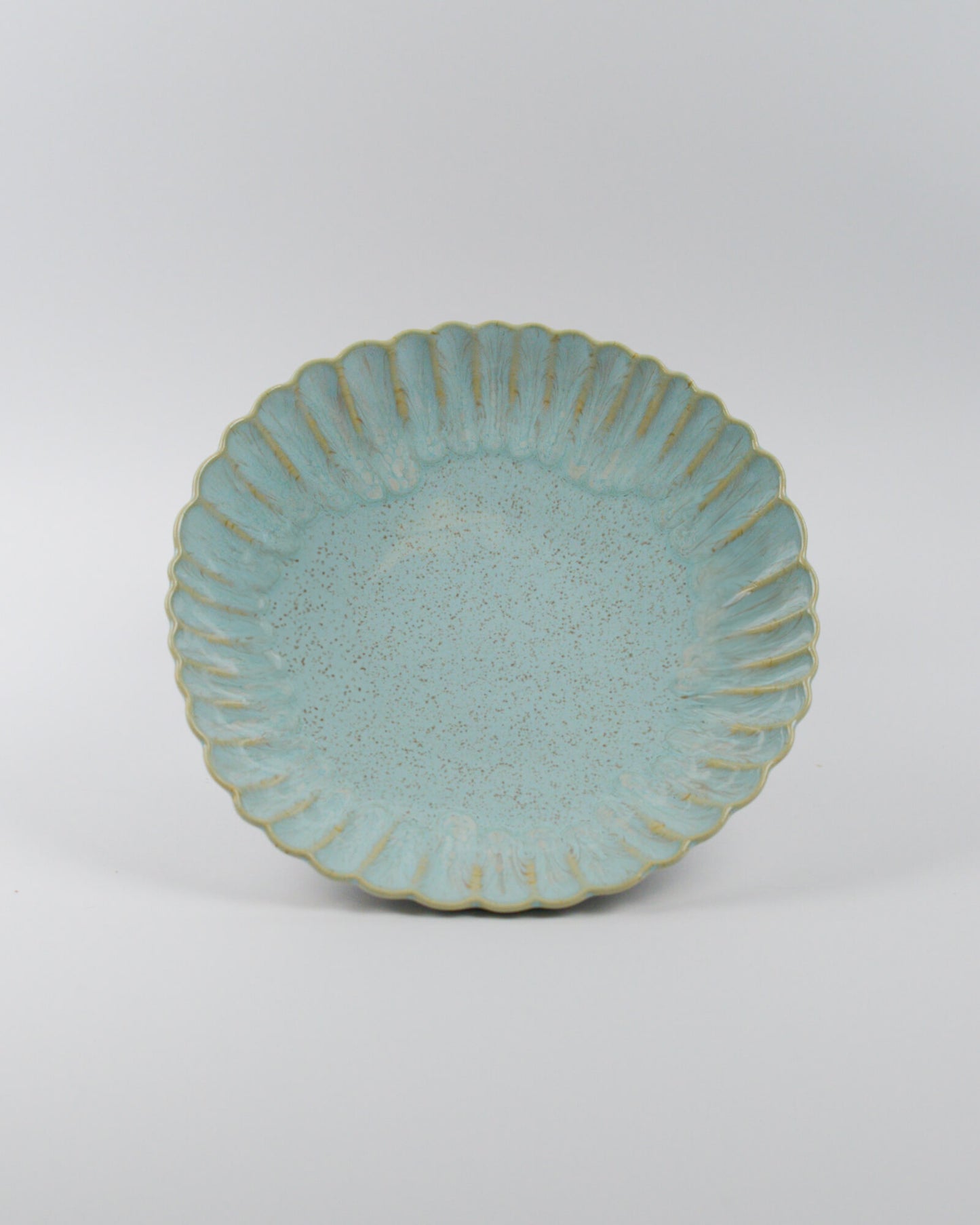 Light blue ceramic pasta bowl with decorative edge on a white background