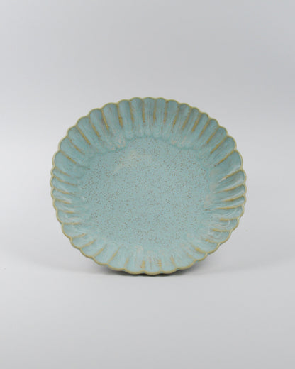 Light blue ceramic pasta bowl with decorative edge on a white background