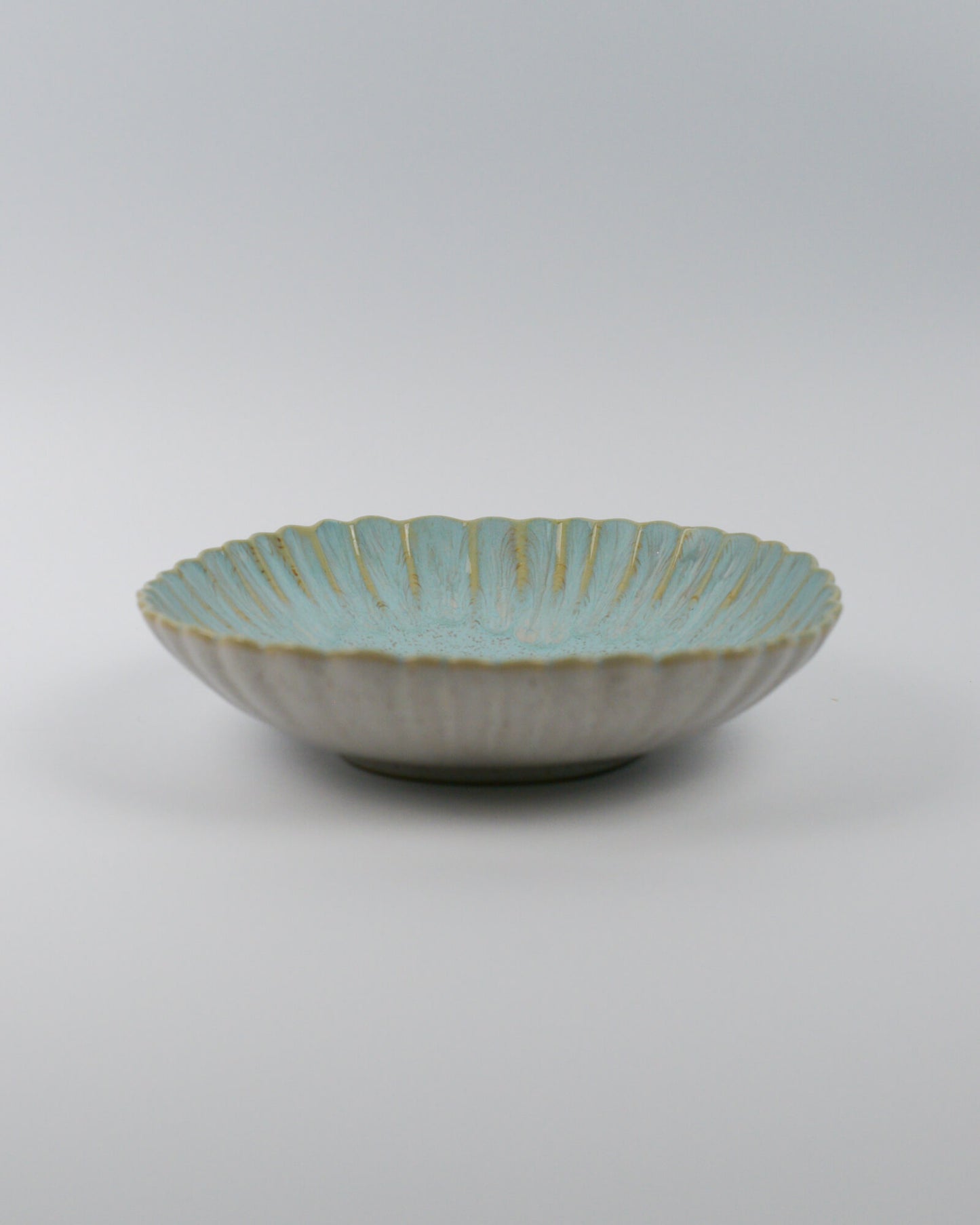 Ceramic pasta bowl with decorative edge on a white background