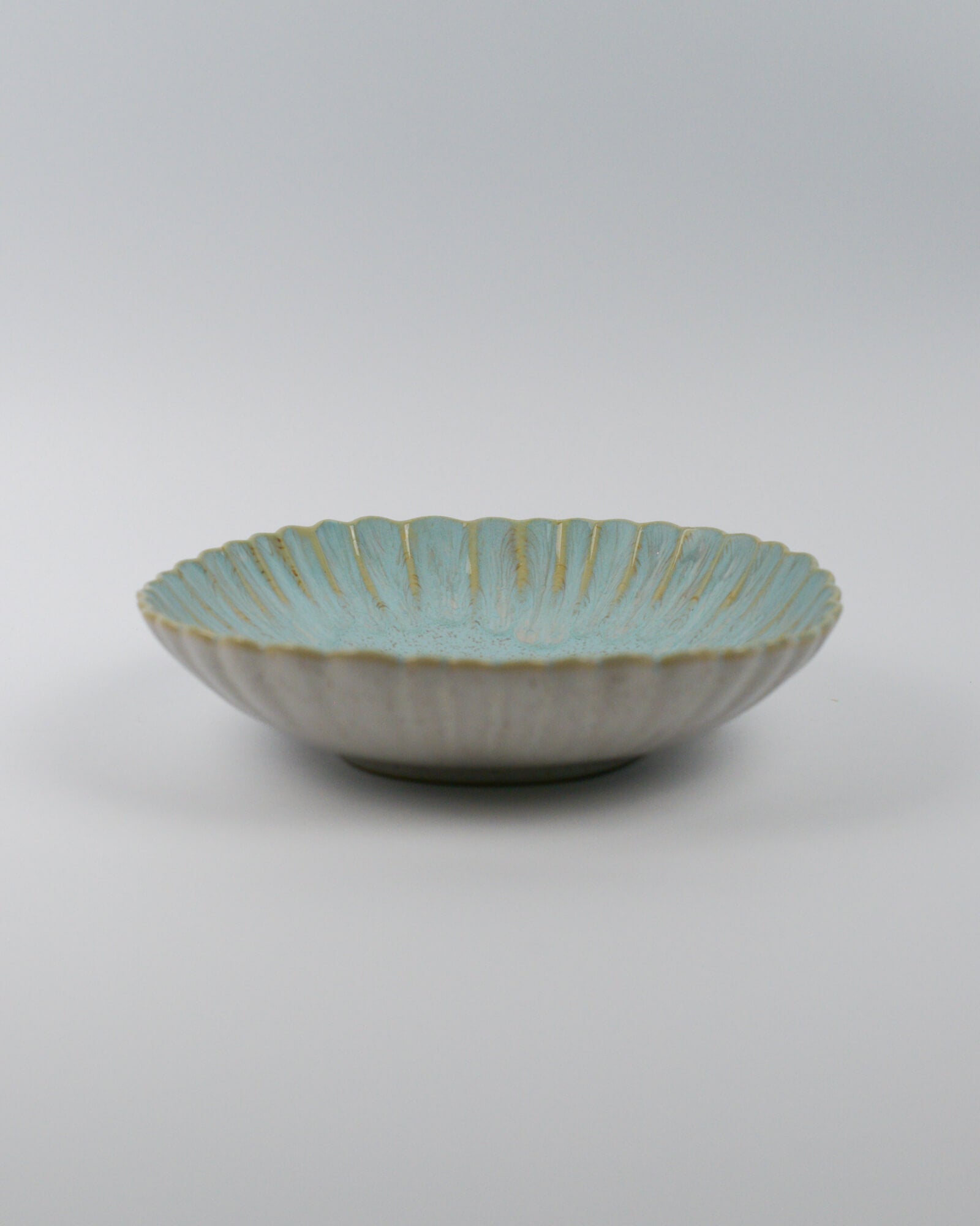 Ceramic pasta bowl with decorative edge on a white background