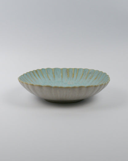 Ceramic pasta bowl with decorative edge on a white background