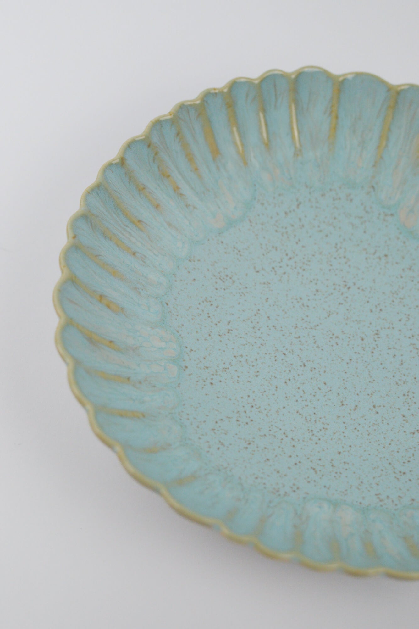 Light blue ceramic pasta bowl with textured surface and decorative edge on a white background