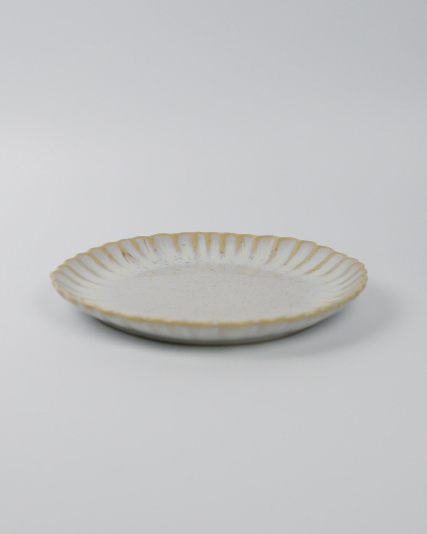 Ceramic salad plate in beige white on a white background