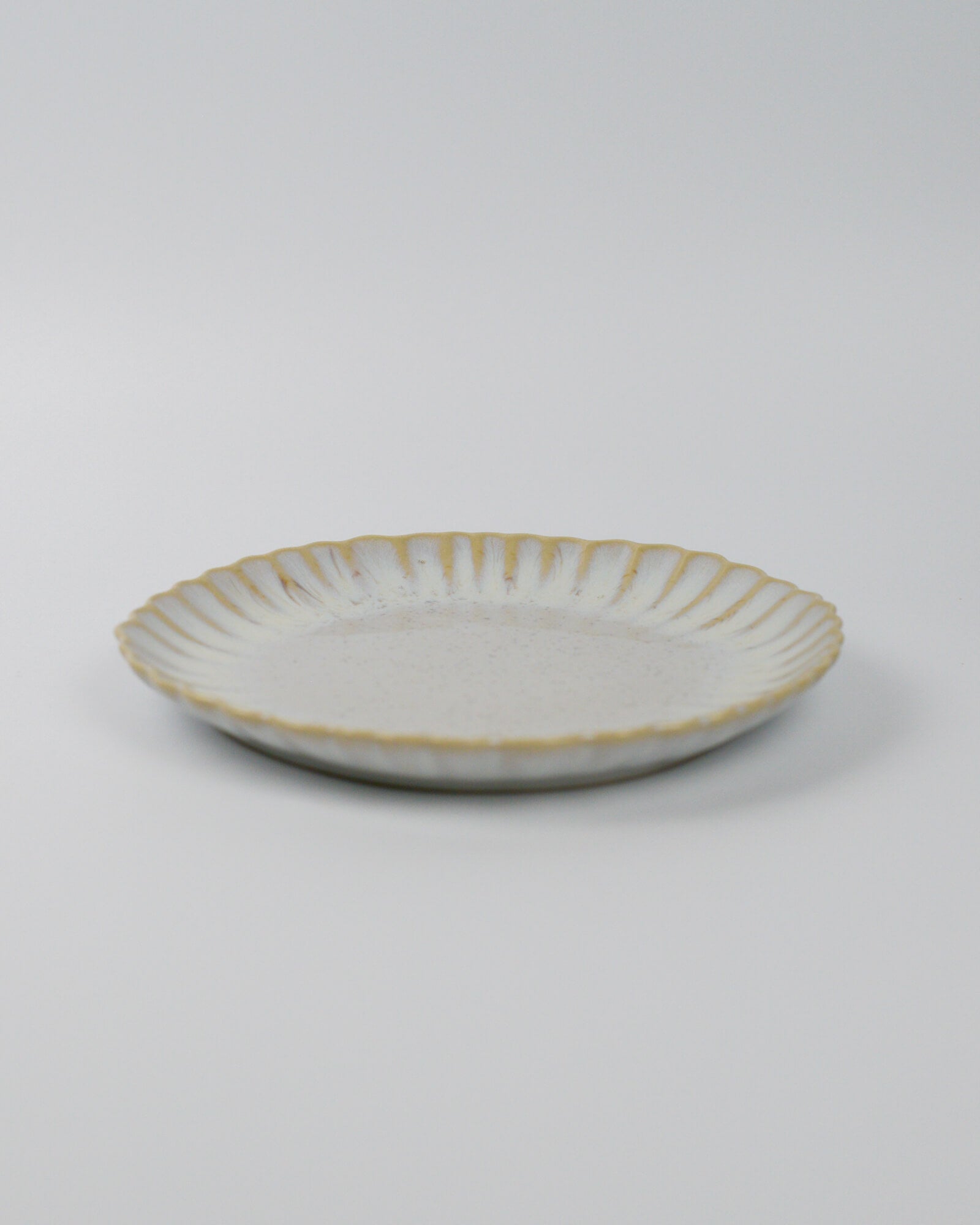 Ceramic salad plate in beige white on a white background