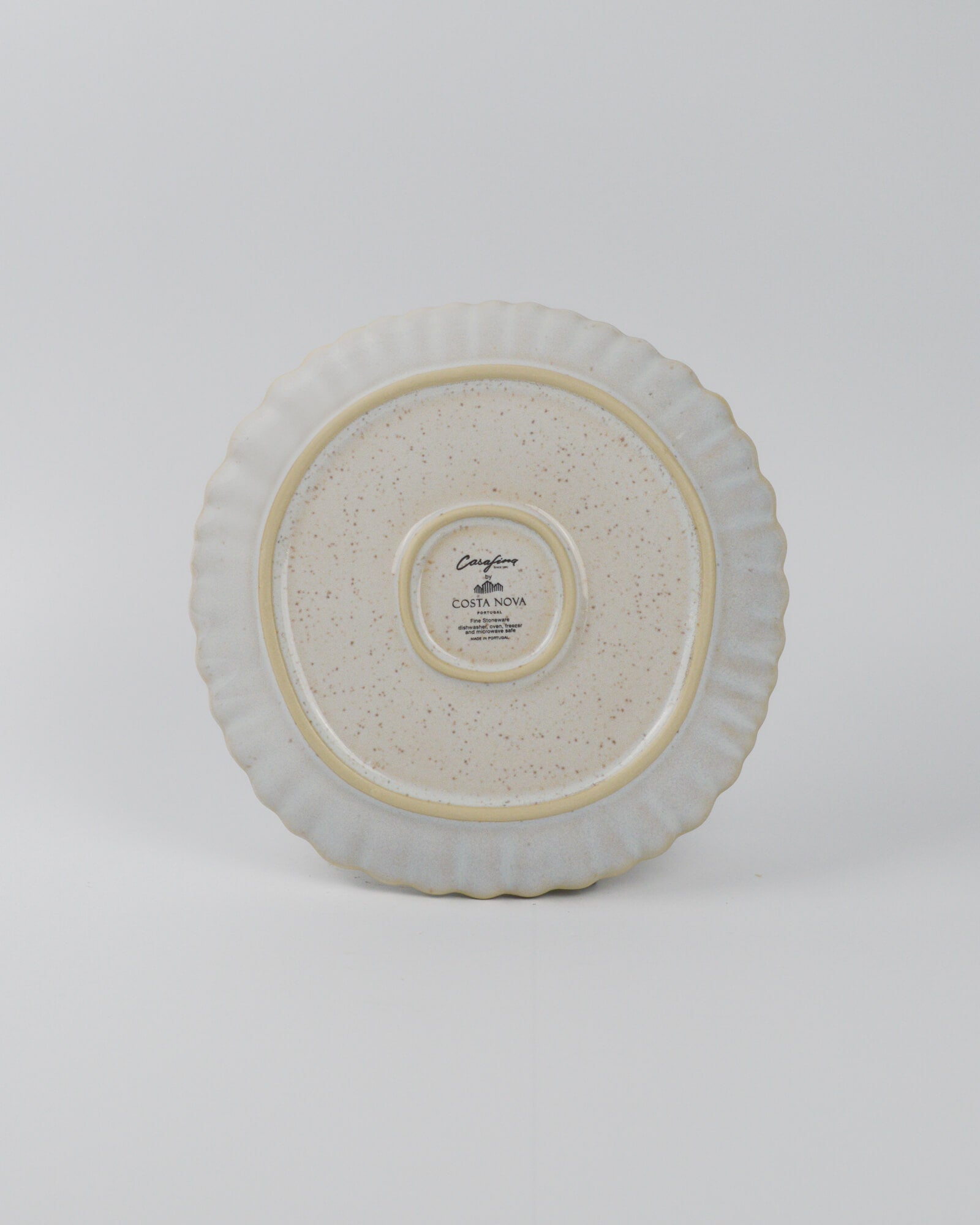 Round ceramic plate with textured surface on a white background