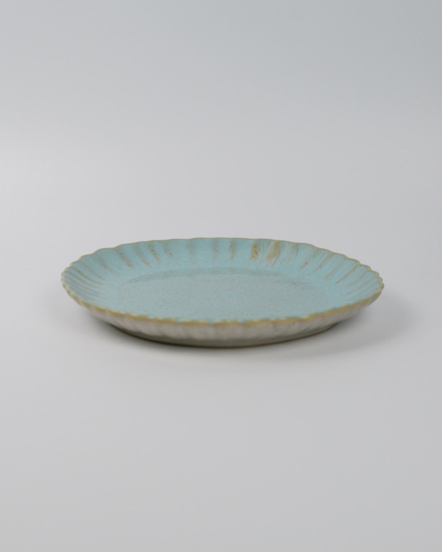 Turquoise ceramic plate on a white background