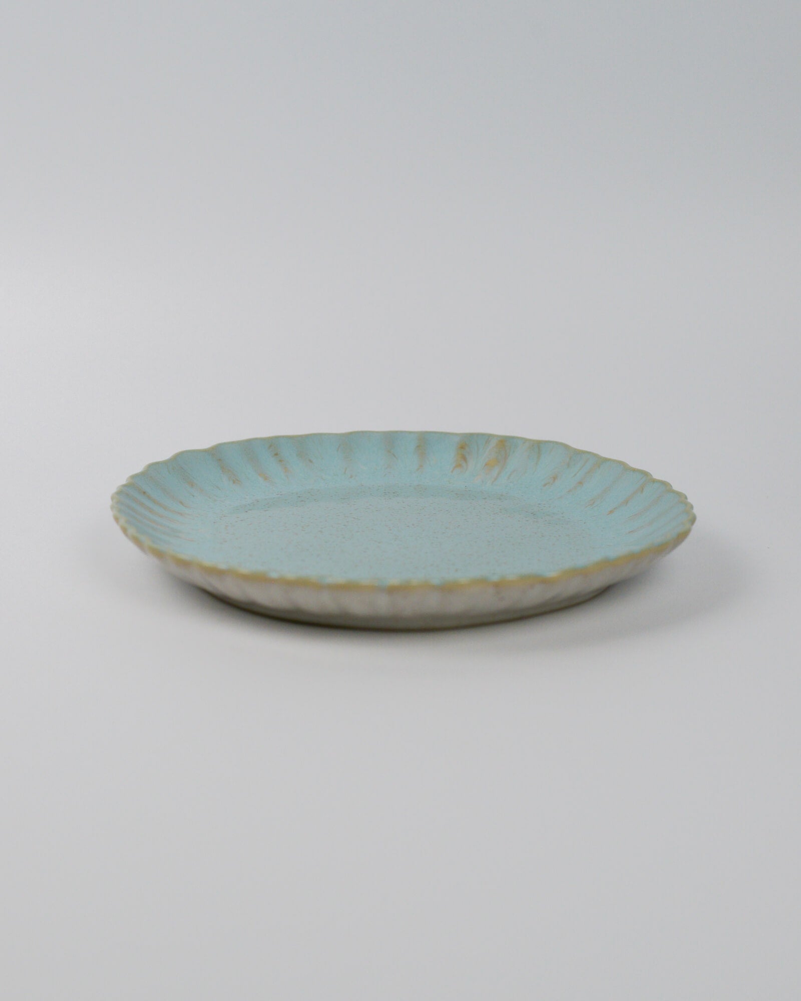 Turquoise ceramic plate on a white background
