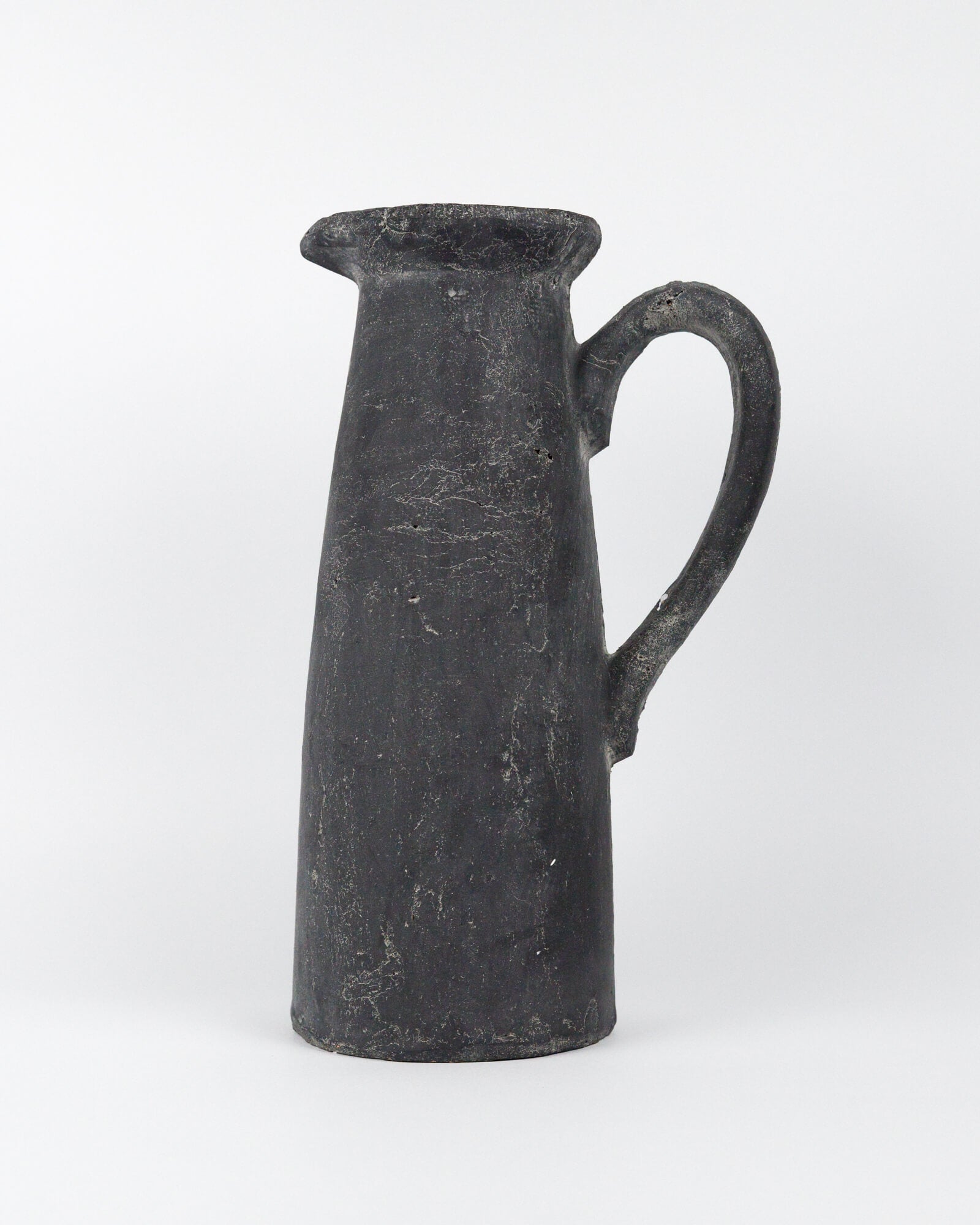 Dark grey ceramic pitcher on a white background