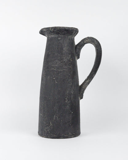 Dark grey ceramic pitcher on a white background