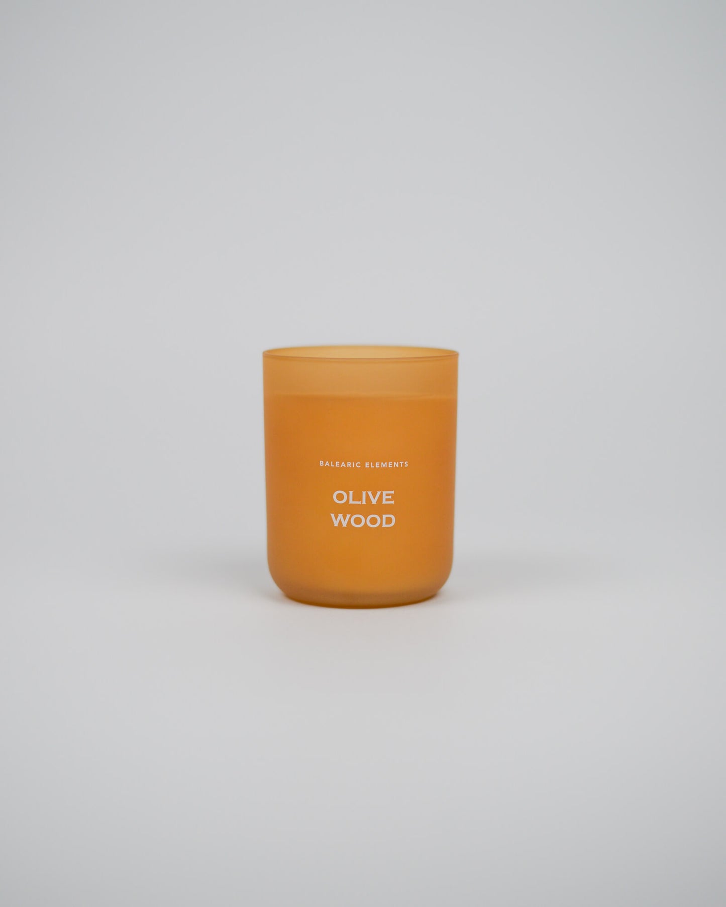 Scented glass candle labeled 'Olive Wood' on a white background