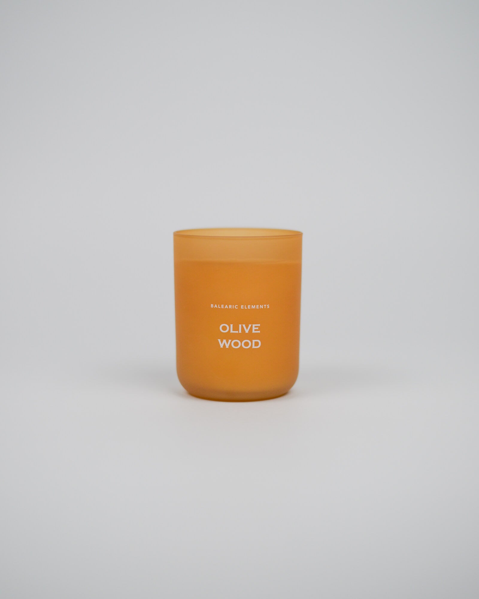 Scented glass candle labeled 'Olive Wood' on a white background