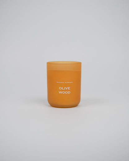 Scented glass candle labeled 'Olive Wood' on a white background