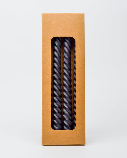 Kraft paper box with a window displaying  twisted black taper candies on a white background