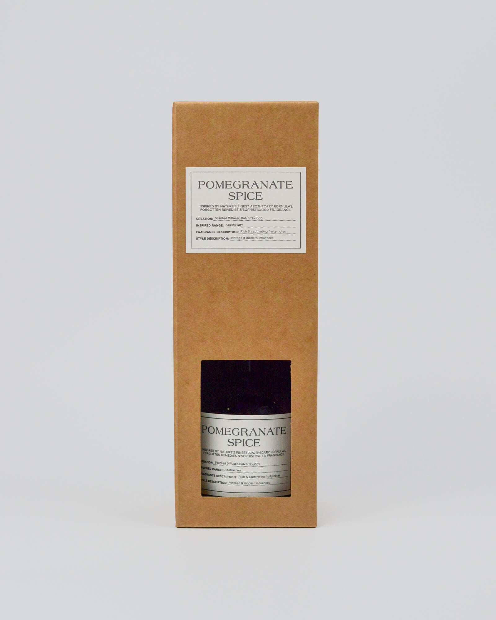 Bottle of 'Pomegranate Spice' in a cardboard box on a white background