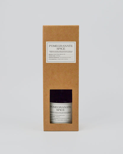 Bottle of 'Pomegranate Spice' in a cardboard box on a white background