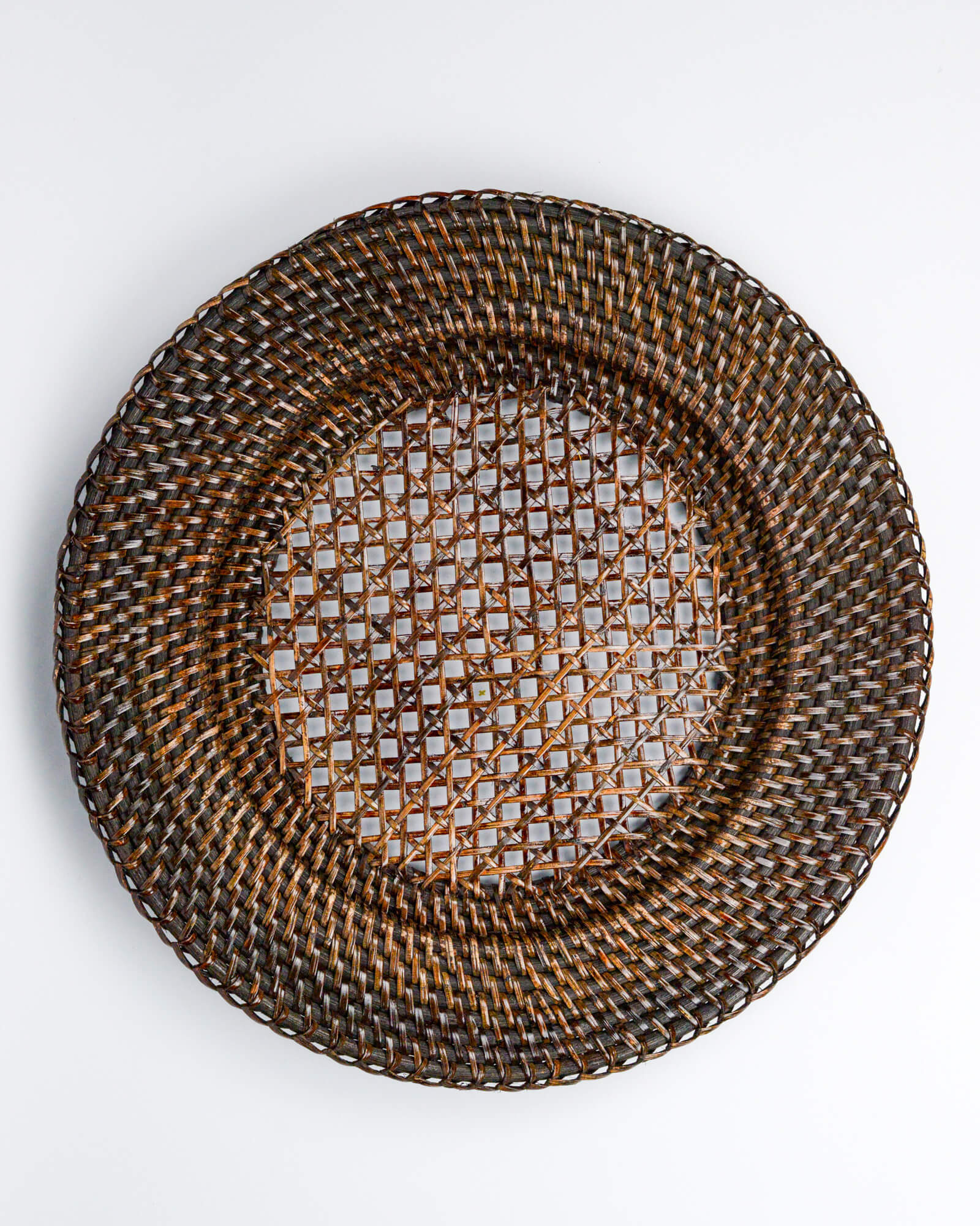 Woven rattan plate on a white background