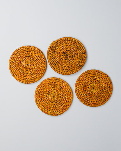 Four round woven coasters on a white background