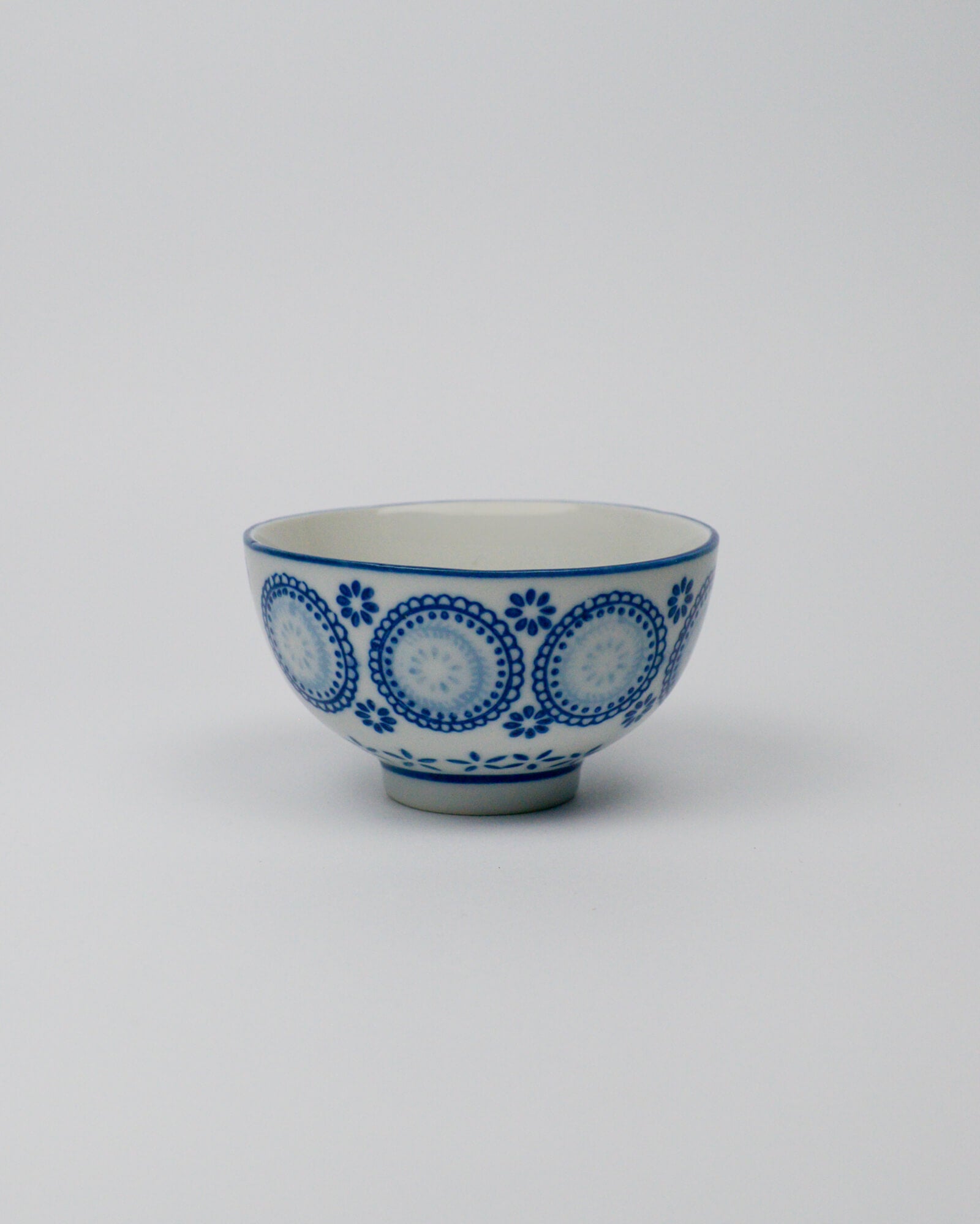 Ceramic bowl with blue circular patterns on a white background