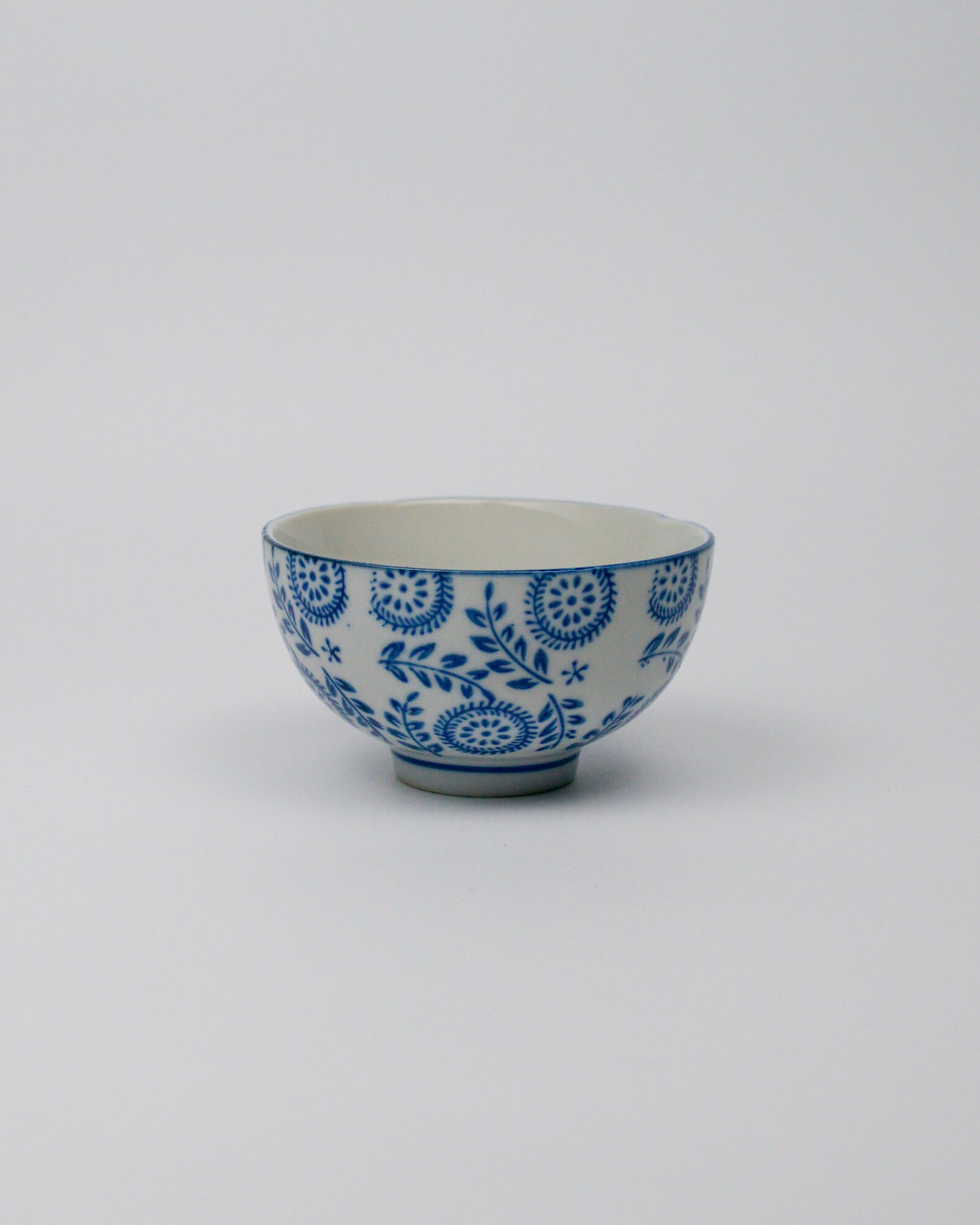 Small ceramic bowl with blue floral patterns on a white background